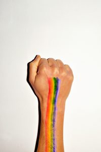 rainbow on the fist of a man against a wall